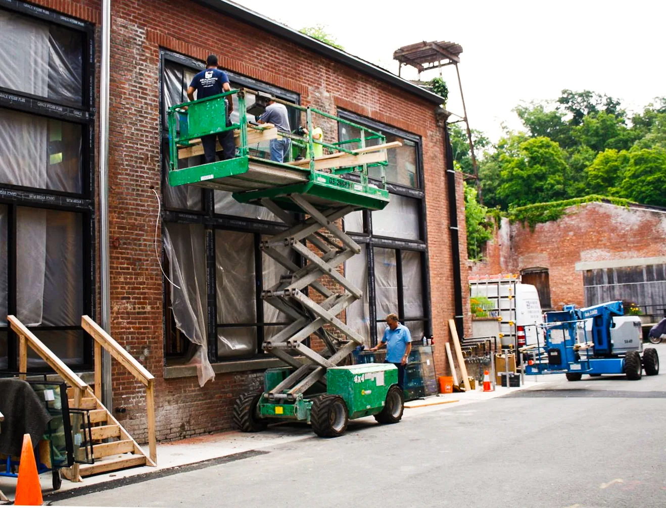 Construction crew working from lifts on a brick building facade