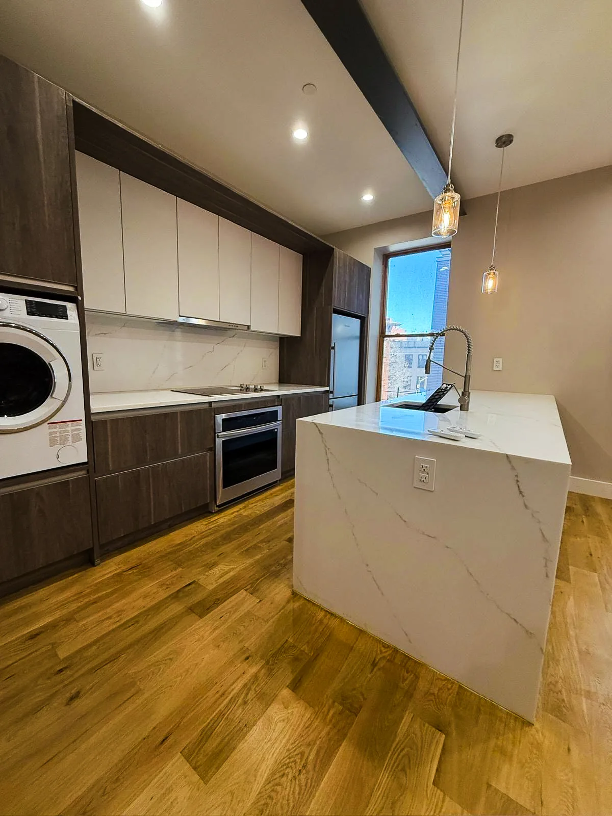 Modern kitchen and laundry area with white countertops