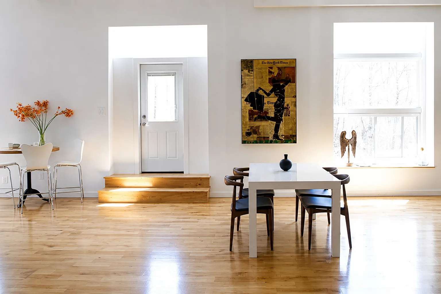 Bright open-plan dining room with wood floors and large windows